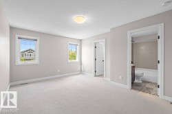 Spacious room with light-toned carpeting, two windows, and a flush-mount ceiling light - 