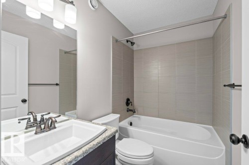 Bathroom featuring a vanity with granite-style countertop, white undermount sink, and brushed nickel faucet - 1627 167 Street Sw, Edmonton, AB - Indoor Photo Showing Bathroom