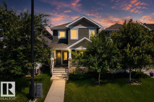 Two-story residence featuring dark siding with white trim accents and a prominent front entrance - 1627 167 Street Sw, Edmonton, AB - Outdoor