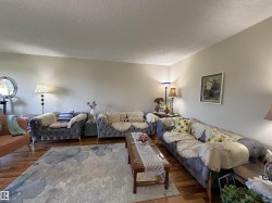 Hardwood flooring throughout featuring light-toned walls and a textured ceiling - 