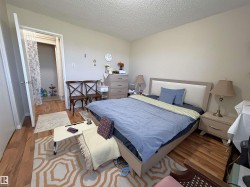Bedroom featuring wood-finish flooring, neutral wall paint, and a textured ceiling - 