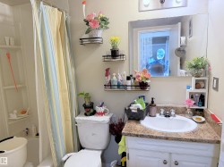 Full bathroom featuring a single vanity with a patterned countertop, integrated sink, and white base cabinetry - 