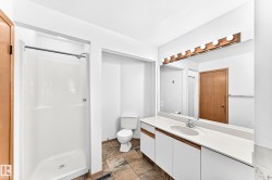 Bathroom featuring a white shower stall, a single vanity with a white countertop, and integrated sink - 