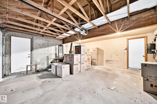 Spacious utility room featuring an exposed wood beam ceiling, concrete flooring, and multiple entry points - 4208 Ramsay Road Nw, Edmonton, AB - Indoor Photo Showing Basement