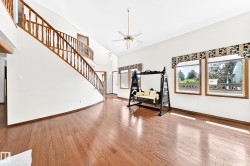 Grand entry foyer featuring a sweeping staircase with wood balusters and railing - 