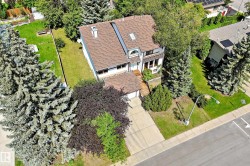 Two-story residence featuring a brown shingle roof, integrated garage, and a concrete driveway - 