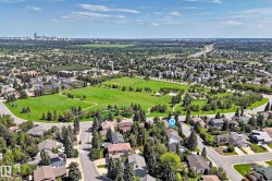 Aerial perspective showcasing expansive green spaces, mature tree-lined streets, and a residential community - 