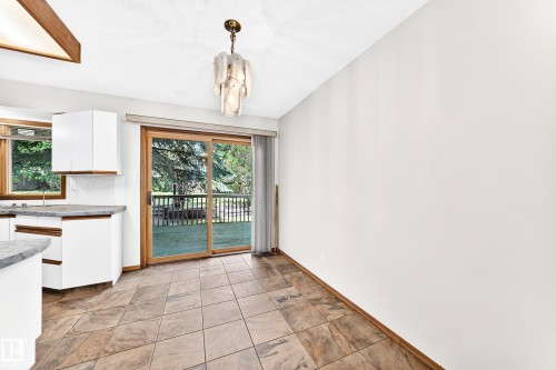 Sliding glass door opening to an exterior deck and green space - 4208 Ramsay Road Nw, Edmonton, AB - Indoor