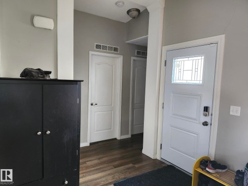 Entryway featuring wood-finish flooring, a paneled door with decorative glass inserts, and a smart lock - 5273 50 Street, Mayerthorpe, AB - Indoor Photo Showing Other Room