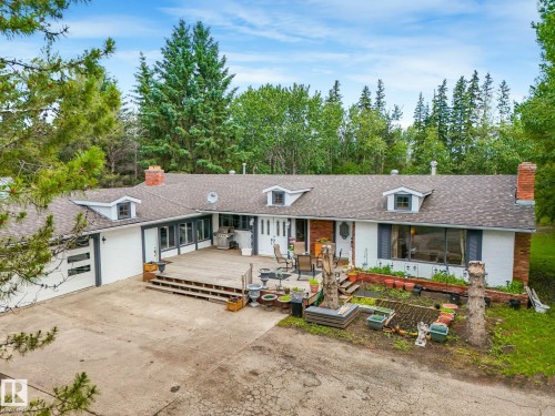 Ranch-style residence featuring a prominent front deck, multiple dormer windows, and two brick chimneys - 10912 5 Avenue Sw, Edmonton, AB - Outdoor With Deck Patio Veranda