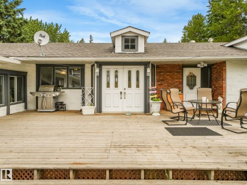 Spacious wood deck with lattice skirting, double entry doors with decorative glass panels, and a secondary entry with an ornate glass insert - 10912 5 Avenue Sw, Edmonton, AB - Outdoor With Deck Patio Veranda With Exterior