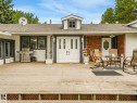 Spacious wood deck with lattice skirting, double entry doors with decorative glass panels, and a secondary entry with an ornate glass insert - 10912 5 Avenue Sw, Edmonton, AB  - Outdoor With Deck Patio Veranda With Exterior 