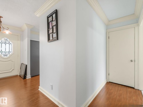 Foyer showcasing wood-finish flooring, white baseboards, and crown molding - 10912 5 Avenue Sw, Edmonton, AB - Indoor Photo Showing Other Room