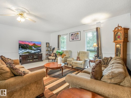 Spacious living area featuring white walls, crown molding, and chair rail detailing - 10912 5 Avenue Sw, Edmonton, AB - Indoor Photo Showing Living Room