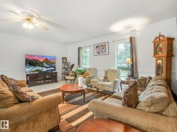 Spacious living area featuring white walls, crown molding, and chair rail detailing - 