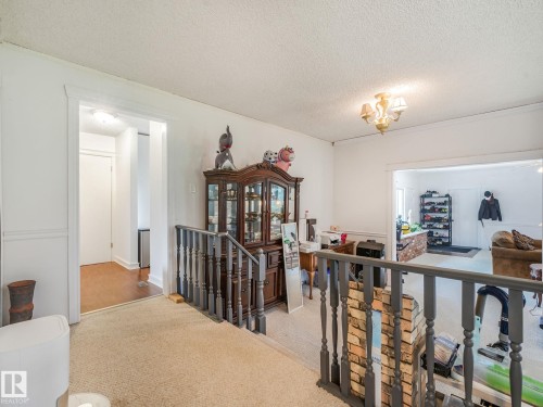 Carpeted landing with painted wood banister - 10912 5 Avenue Sw, Edmonton, AB - Indoor Photo Showing Other Room
