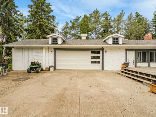White brick exterior with a gray-trimmed garage door featuring horizontal window panels - 10912 5 Avenue Sw, Edmonton, AB - Outdoor