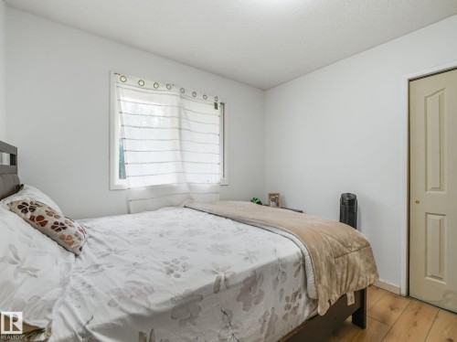 Bright room featuring white walls and wood-finish flooring - 10912 5 Avenue Sw, Edmonton, AB - Indoor Photo Showing Bedroom