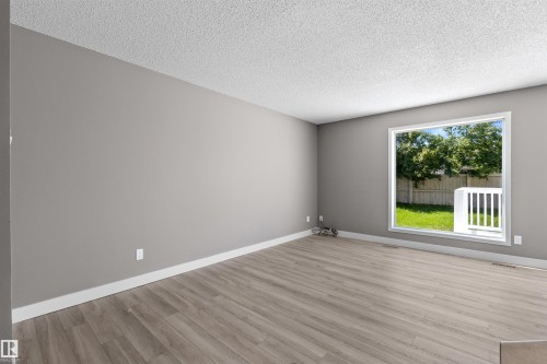 Large picture window with patio slider door for airflow and light. - 6837 159A Avenue Nw, Edmonton, AB - Indoor Photo Showing Other Room