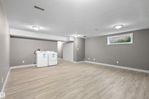 Basement with new vinyl plank floors, a large egress window, and brand new washer and dryer - 6837 159A Avenue Nw, Edmonton, AB - Indoor