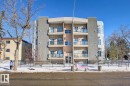Multi-story residential building featuring a light beige facade with contrasting textured grey panels - 102 10905 109 Street, Edmonton, AB  - Outdoor With Facade 