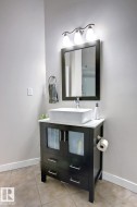 Dark wood vanity with a white vessel sink, complemented by a white countertop - 