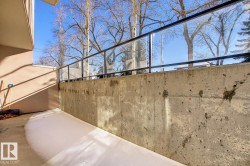 Outdoor patio area with a concrete surface and a glass-paneled railing - 