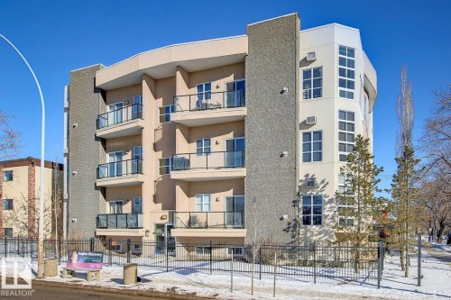Contemporary multi-story building featuring a stucco and stone exterior, multiple private balconies with glass railings, and expansive windows - 102 10905 109 Street, Edmonton, AB - Outdoor With Facade