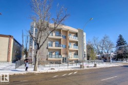 Contemporary multi-story building featuring stucco and stone-finish exterior, multiple private balconies with glass railings, and expansive window panels - 