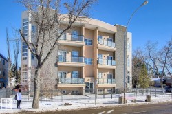 Multi-story residential building featuring a stucco exterior with stone veneer accents - 