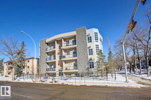 Modern multi-story residential building featuring a light-toned stucco exterior with stone veneer accents - 102 10905 109 Street, Edmonton, AB - Outdoor With Facade