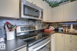 Modern kitchen featuring stainless steel appliances, including an over-the-range microwave and an electric range - 