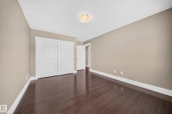 Room featuring deep wood-finish flooring, neutral wall tones, and white baseboards - 