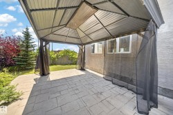 Stamped concrete patio featuring a metal gazebo with mesh screens - 