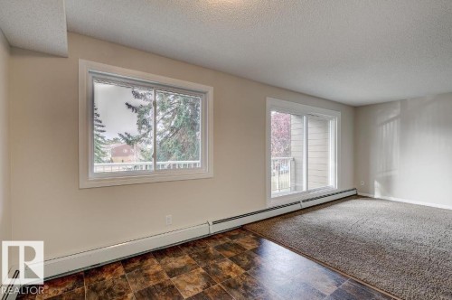 Spacious room featuring a large window and sliding glass door - 5425 144B Avenue Northwest, Edmonton, AB - Indoor Photo Showing Other Room