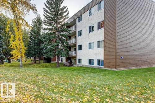 Four-story apartment building featuring a textured white facade and brown siding - 5425 144B Avenue Northwest, Edmonton, AB - Outdoor