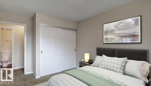 Bedroom featuring neutral wall paint, textured carpeting, and white bi-fold closet doors - 5425 144B Avenue Northwest, Edmonton, AB - Indoor Photo Showing Bedroom