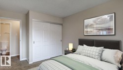 Bedroom featuring neutral wall paint, textured carpeting, and white bi-fold closet doors - 
