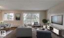 Open-concept living area with wood-finish flooring and a large sliding glass door opening to a balcony - 5425 144B Avenue Northwest, Edmonton, AB  - Indoor Photo Showing Living Room 
