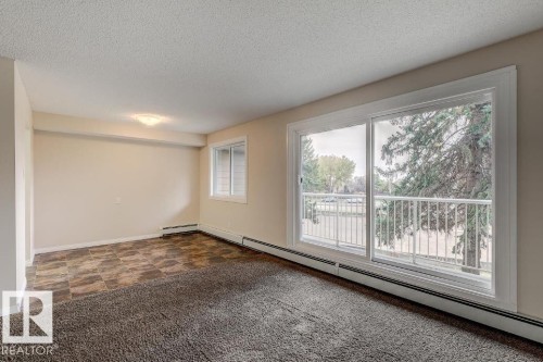 Sliding glass patio doors opening to a white metal balcony railing, complemented by a secondary window - 5425 144B Avenue Northwest, Edmonton, AB - Indoor Photo Showing Other Room