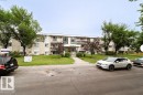 Three-story stucco and siding building with multiple balconies, a central entrance, and a manicured front lawn - 3312 105 Avenue Northwest, Edmonton, AB  - Outdoor 