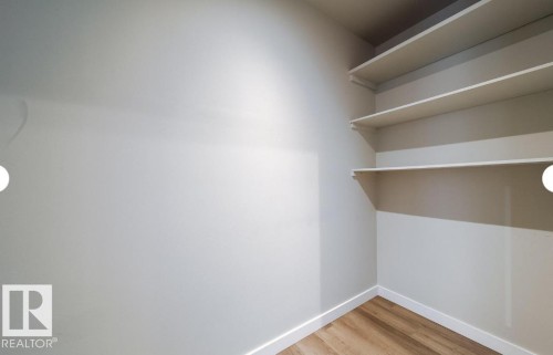 Interior room featuring light-colored walls and wood-finish flooring - 3312 105 Avenue Northwest, Edmonton, AB - Indoor With Storage