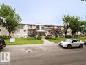 Three-story stucco and siding building with multiple balconies, a central entrance, and a manicured front lawn - 3312 105 Avenue Northwest, Edmonton, AB  - Outdoor 