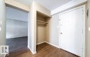 Entryway featuring wood-finish flooring, a built-in coat closet with shelving, and a clean white entry door - 3312 105 Avenue Northwest, Edmonton, AB  - Indoor Photo Showing Other Room 