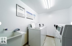 Dedicated laundry area featuring multiple washing machines and dryers - 