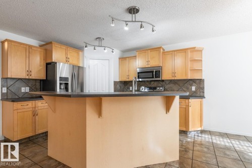 Kitchen With Bar-Style Counter That Will Hold 2 Bar Stools. - 4717 60 Street, Beaumont, AB 