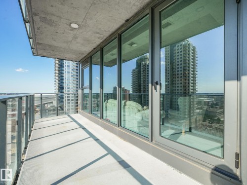 Expansive private balcony featuring a concrete floor and ceiling, floor-to-ceiling glass panel windows, and a glass-paneled railing system - #1501 10180 103 St Nw, Edmonton, AB - Outdoor With Balcony With Exterior