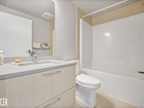 Bathroom featuring a white bathtub, toilet, and vanity with a light wood-finish cabinet - #1501 10180 103 St Nw, Edmonton, AB - Indoor Photo Showing Bathroom