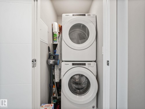 Dedicated laundry closet featuring a stacked washer and dryer unit - #1501 10180 103 St Nw, Edmonton, AB - Indoor Photo Showing Laundry Room