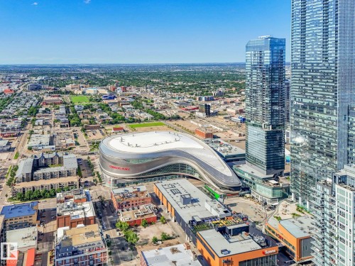 Aerial perspective showcasing a modern urban landscape with multiple high-rise buildings and a prominent architectural stadium structure - #1501 10180 103 St Nw, Edmonton, AB - Outdoor With View